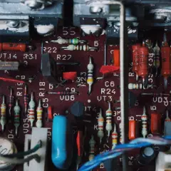 Wnętrze wzmacniacza samochodowego z widocznymi rezystorami, kondensatorami i innymi elementami elektronicznymi. To zdjęcie może pomóc zrozumieć, jak podłączyć wzmacniacz samochodowy.