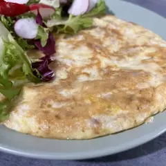 Omlet z sałatką na talerzu, idealny na śniadanie. Znajdziesz więcej takich przepisów na blogu fodmap przepisy.