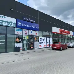 Budynek z szyldami "Diagnostyka", "Centrum Podróży", "Unilink Ubezpieczenia" i "Rossmann".