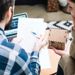 Pareja revisa documentos, planeando el futuro de su hogar, cuando un contrato de alquiler se convierte en indefinido.