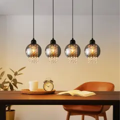 Elegancka lampa wisząca kryształowa z czterema kulistymi kloszami, ozdobiona błyszczącymi kryształkami, tworzy magiczny blask nad stołem.