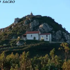 Edificio blanco con tejado rojo en la ladera rocosa del Pico Sacro.