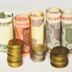 Zwijane banknoty i monety pokazują, jaka waluta w Indiach jest używana: rupie indyjskie o nominałach 5, 10, 20, 50 i 100.
