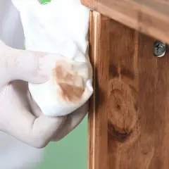 Guante de látex retira barniz de mueble de madera. Paso a paso para decapar un mueble de madera barnizado.