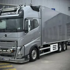 Srebrny Volvo FH16 z naczepą chłodniczą, ozdobiony dodatkowymi światłami i napisem "Słoneczne Pole".