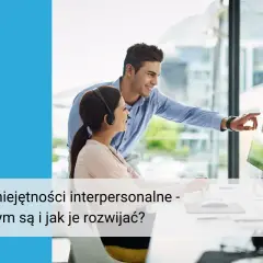 Dwóch współpracowników, kobieta z zestawem słuchawkowym i mężczyzna, omawia projekt przy komputerze. Doskonałe umiejętności interpersonalne w pracy kluczem do sukcesu.
