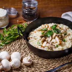Un crémeux risotto poulet champignon, garni de basilic frais, prêt à être dégusté.