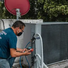 Technik sprawdza czujnik ciśnienia klimatyzacji za pomocą manometru.