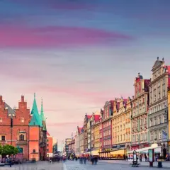Rynek we Wrocławiu z Ratuszem i kolorowymi kamienicami o zachodzie słońca.