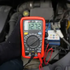 Multimetr pokazuje 12.72V, co może oznaczać, że akumulator nie trzyma napięcia. Sprawdzanie stanu baterii w samochodzie.