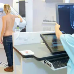 Frau wird mittels 3D Mammographie untersucht. Ärztin analysiert das Bild auf dem Monitor.
