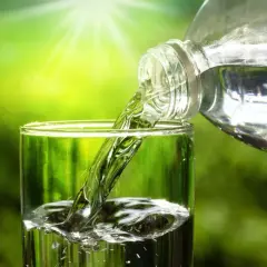 Verre rempli d'eau pure, versée d'une bouteille. L'eau du robinet, sans TDS, est rafraîchissante.