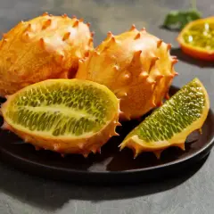 Kiwano, jak jeść? Kolczasty owoc pokrojony na pół, ukazujący zielony, galaretowaty miąższ z pestkami. Idealny do deserów i koktajli.