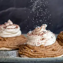 Deliciosas tartas Mont Blanc con crema batida y espolvoreadas con azúcar glas y cacao.