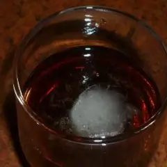 Szklanka z bursztynowym trunkiem i kostką lodu. Czekam na ten wyjątkowy metaxa smak.