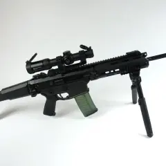 Czarny karabin z celownikiem optycznym Vortex Strike Eagle i zielonym magazynkiem. Kolimator do grota zapewnia precyzyjne celowanie.