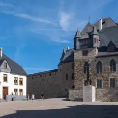Ein imposantes Schloss mit steinernen Mauern und Türmen. Perfekt für einen Ausflug, um die Burg zu erkunden und danach durch die Umgebung zu wandern.