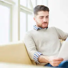 Mężczyzna analizuje dokumenty, szukając informacji, jak dostać kredyt na mieszkanie.