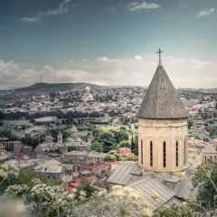 Widok na Tbilisi z kościołem w pierwszym planie. Marzysz o podróży? Sprawdź, ile trwa lot do Gruzji!
