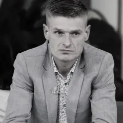 Tomasz Komenda, mimo młodego wieku, ma za sobą trudne doświadczenia. Na zdjęciu w garniturze i wzorzystej koszuli.