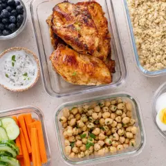 Vorbereitete Mahlzeiten für clean eating: Hähnchenbrust, Quinoa, Kichererbsen, Gemüse-Sticks, Blaubeeren und hartgekochte Eier.