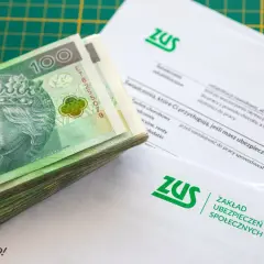 Stos dokumentów ZUS i plik banknotów 100 zł. Zastanawiasz się, ile wynosi składka ZUS dla jednoosobowej firmy?
