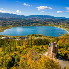 Widok na zamek, jezioro i jesienne Karkonosze.