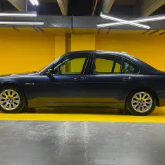 Eleganckie bmw e67 w ciemnym kolorze, zaparkowane na tle jaskrawożółtej ściany.