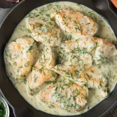 Pyszny kurczak w sosie śmietanowym z koperkiem, podany w żeliwnej patelni. Aromatyczny i kremowy.