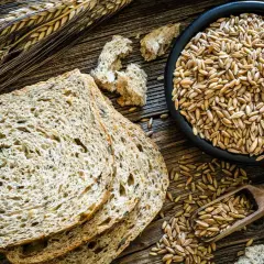 Vollkornbrot mit Dinkel oder Roggen, Körner in einer Schüssel und auf einem Löffel. Gut für Diabetes.