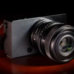 Elegancki aparat Sigma z obiektywem na drewnianym blacie.