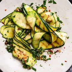 Zucchine grigliate condite con erbe fresche, aglio, sale grosso e peperoncino. Un'idea semplice per gustare le zucchine.