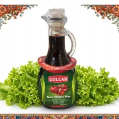 Butelka sosu z granatu Nar Ekşili Sos na tle sałaty, ozdobiona orientalnymi wzorami.