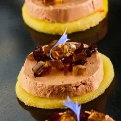 Délicieuse terrine de foie gras sur une tranche d'ananas, garnie de dés de gelée et d'une fleur bleue. Un vrai régal pour savoir comment démouler une terrine de foie gras.