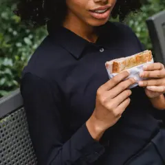 Frau hält Sandwich, wie bei der Sandwich-Methode für Feedback.