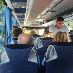 Pasażerowie w wygodnym autokarze do Londynu podziwiają zielone krajobrazy za oknem.