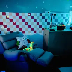 Chaise confortable et lumineuse pour une séance snoezelen, avec des étoiles au mur et une colonne à bulles.