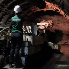 W kopalni Guido przewodnik w zielonej koszulce i kasku obsługuje maszynę. Warto wiedzieć, jak się ubrać na taką wycieczkę.