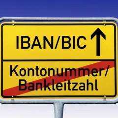 Gelbes Ortsschild mit "IBAN/BIC" und Pfeil nach oben. Darunter "Kontonummer/Bankleitzahl" durchgestrichen.