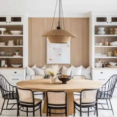 Chic dining table decor ideas: a round wood table with cane chairs, a woven pendant light, and built-in shelving.