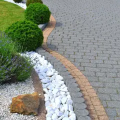 Zadbany ogród z lawendą i trawnikiem, gdzie impregnacja kostki brukowej zapewnia jej trwałość i piękny wygląd.