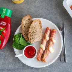 Parówki po kanadyjsku zawinięte w boczek z serem, podane z chlebem, szpinakiem i ketchupem Kotlin.