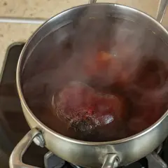 Cuisson de betteraves rouges dans une casserole d'eau bouillante. La vapeur s'échappe de la cocotte.