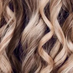 Falujące, blond włosy z subtelnymi refleksami, jak po letnim słońcu. Technika flamboyage nadaje im naturalny, trójwymiarowy efekt.