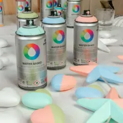 Latas de spray de pintar espuma poliuretano en tonos pastel, listas para dar color a figuras de poliestireno.