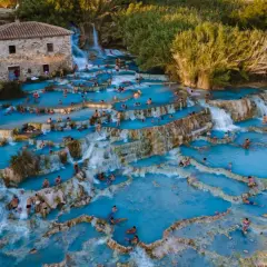 Cascate termali con gente che si rilassa. Per sapere come arrivare alle terme di Saturnia, guarda questa meraviglia naturale.