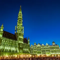 Wieczorem na Grand Place w Brukseli, oświetlone ratusz i kamienice tworzą magiczny widok.