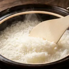 Ångande, fluffigt ris i en keramikgryta, redo att serveras. Ris nyttigt och gott!