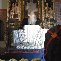Ołtarz w kościele z grobem Chrystusa, ozdobiony ciernistymi gałęziami i świecą.