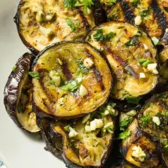 Aubergines grillées au four, garnies d'ail et de persil frais. Une recette simple et savoureuse pour sublimer ce légume.